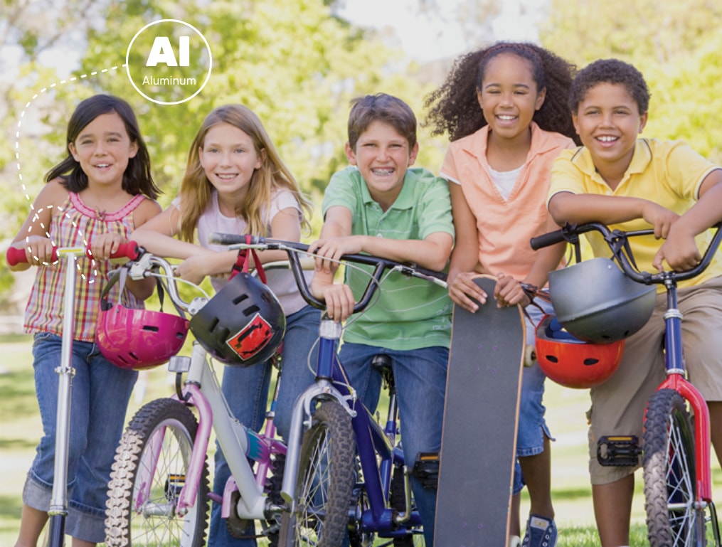 Image of five children riding bicycles, scooters and skateboards. They are happy and outdoors. Aluminum is used in scooters and bicycles.