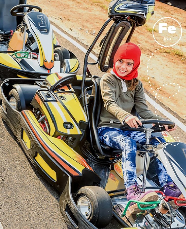 Image of a child driving a go-kart. Iron is used in the frames of go-karts.